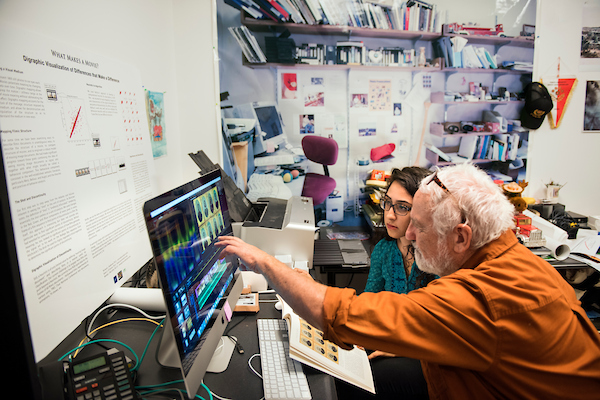 A student and faculty member working at a monitor