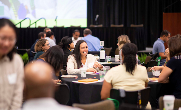 Individuals chatting at a table during a campus event