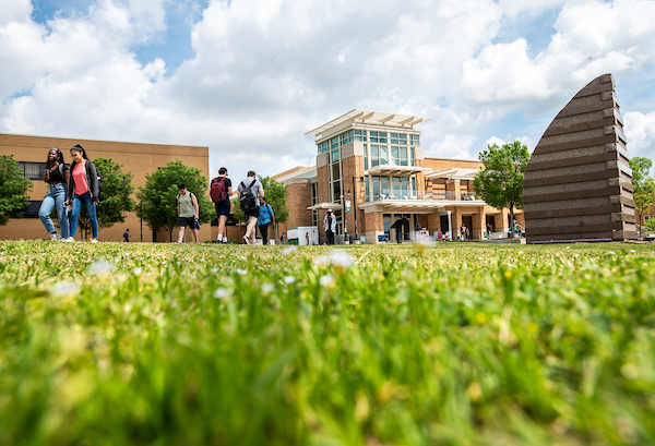 Low-angle photo of students walking near the UNT Union