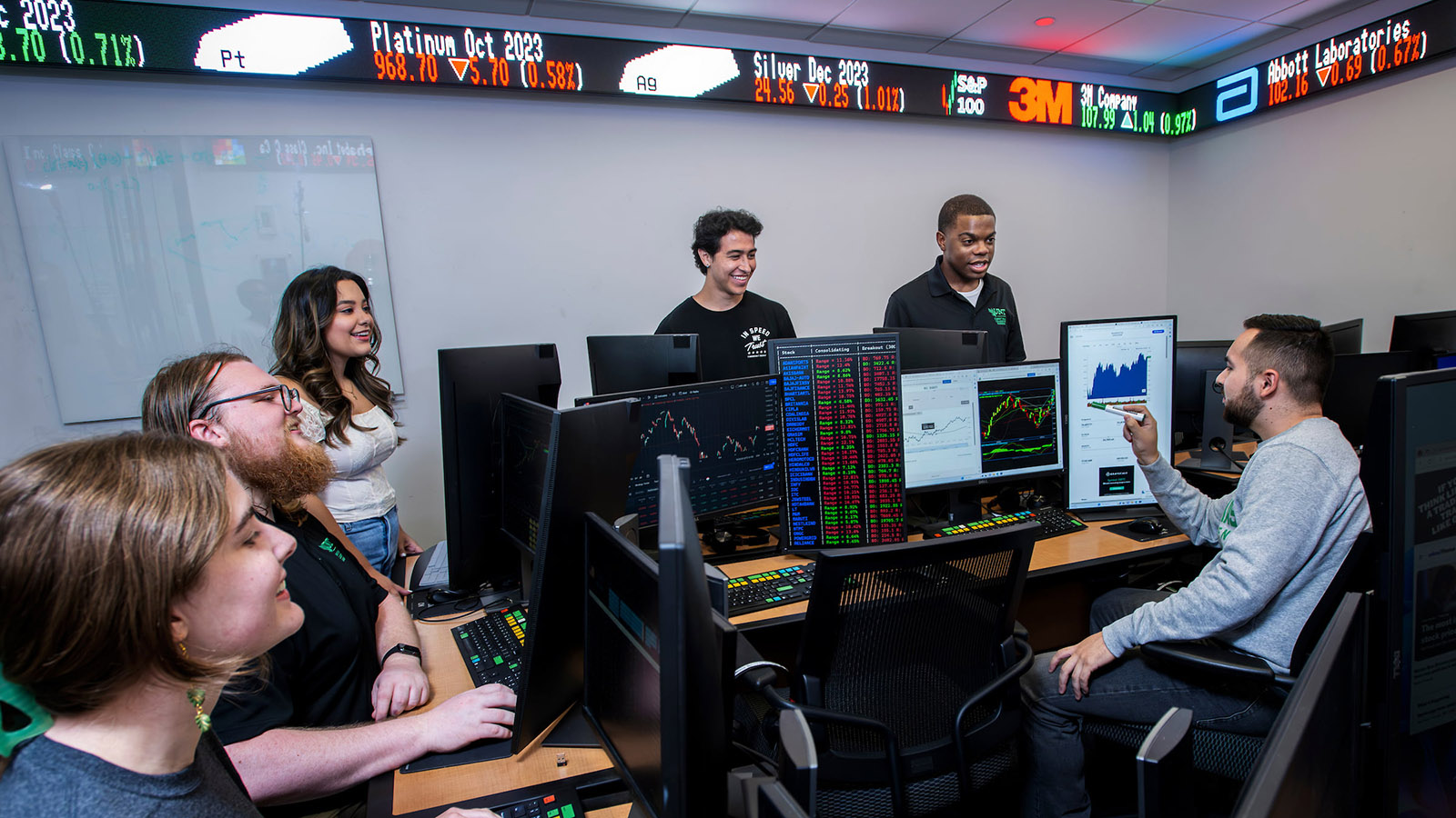 Business students work in the stock exchange room in the College of Business building