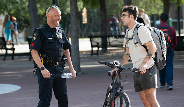 UNT police officer chatting with a student on campus