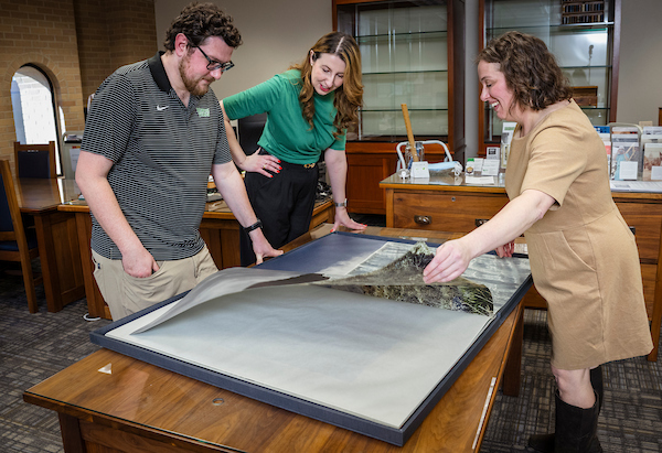 Researchers view a large document at UNT Libraries' Special Collections