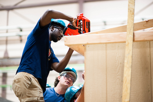 Two construction management students work with power tools in the College of Engineering's Tiny Homes Lab.
