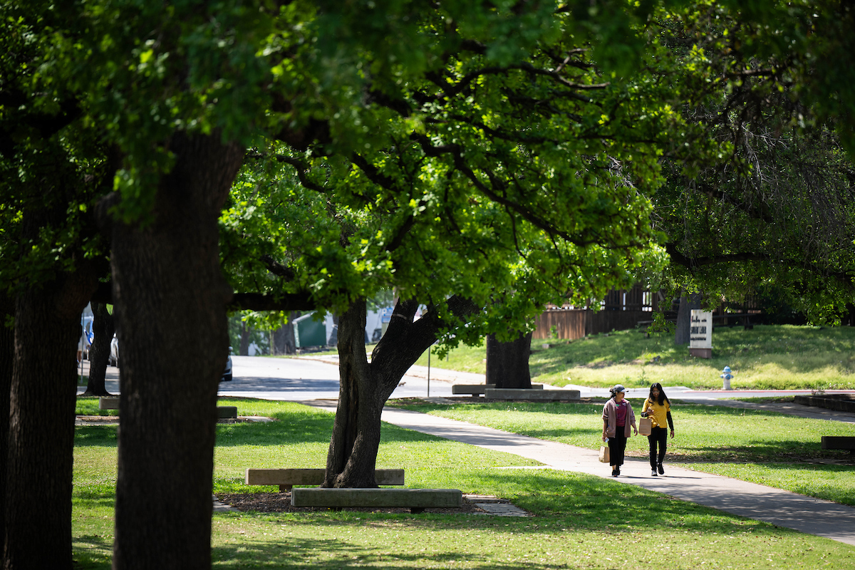 Two people walking on a campus path