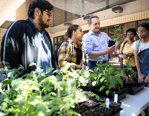 A history professor with students at a plant giveaway event