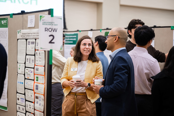 Faculty chatting near research posters