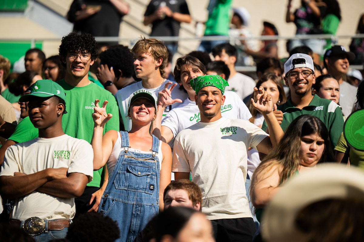 Fans making the "claw" hand sign at a UNT game