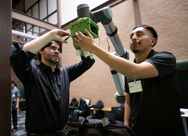 Two engineering students assemble a senior design project
