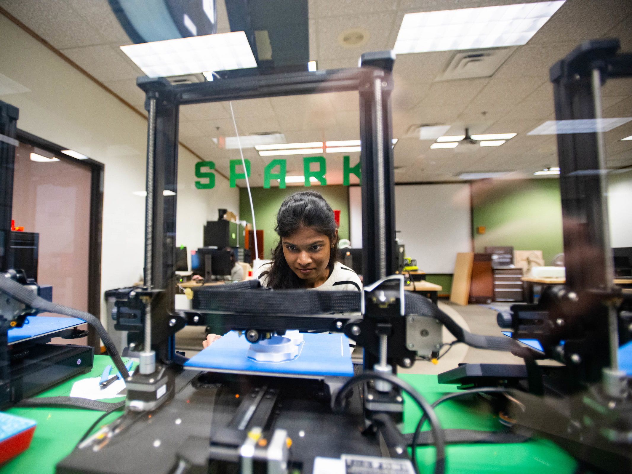 Seemaparevez Shaik working with a 3D printer in The Spark 