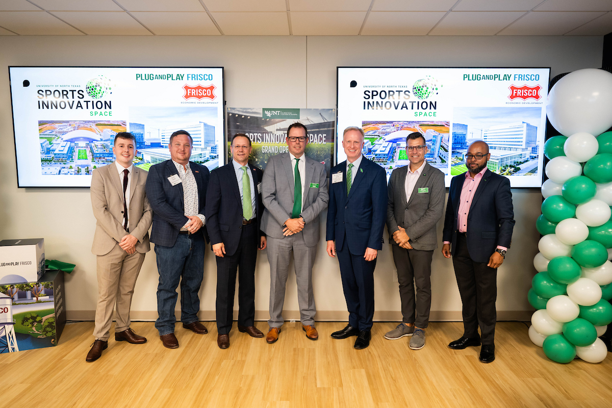 Group photo of SEM student Elliot Stockdale; David Steele, Director of Plug and Play; Jason Ford, President of Frisco EDC; Bob Heere, professor of sport management; UNT President Keller; Matthew Walker, professor of management; SEM student Malcolm Gomez